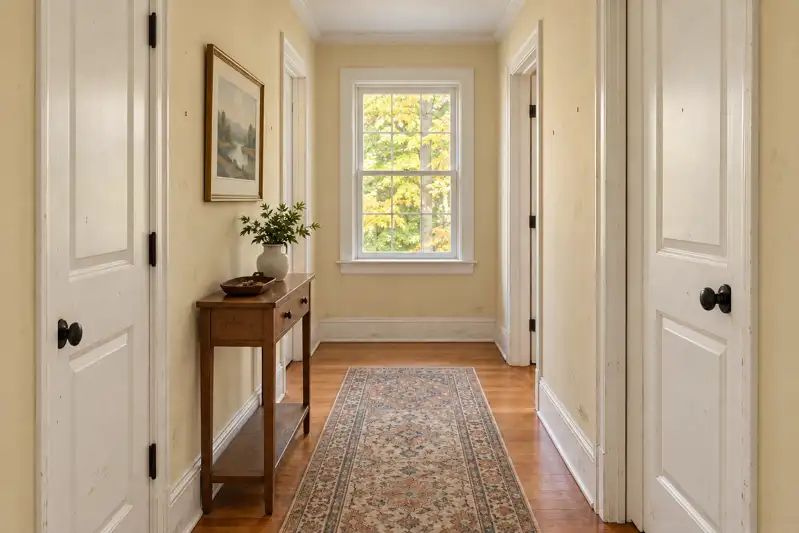 Illustrative before: dated paint and everyday wear in the same hallway